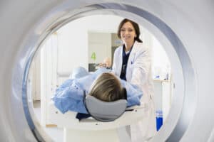 female doctor looking at patient undergoing CT scan
