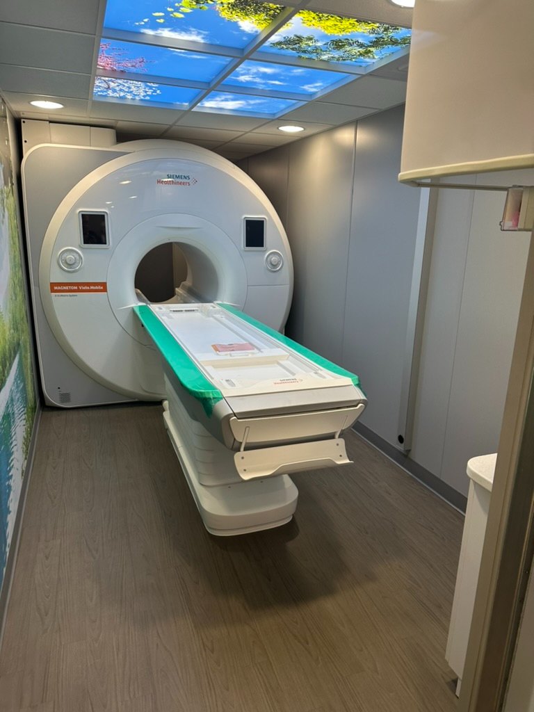 Interior of a mobile MRI trailer showing the scanner bore and patient table