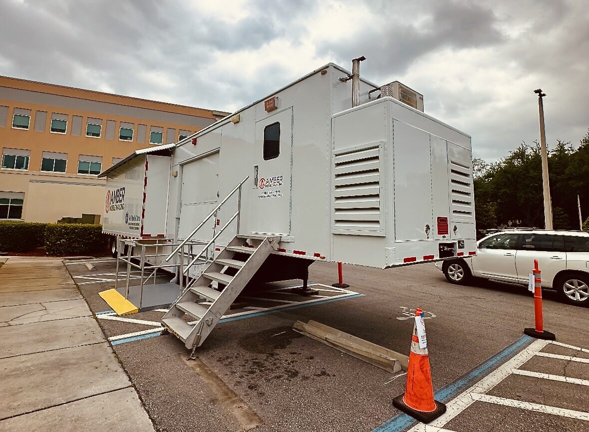Mobile PET/CT trailer set up at a hospital with patient access stairs and ramp